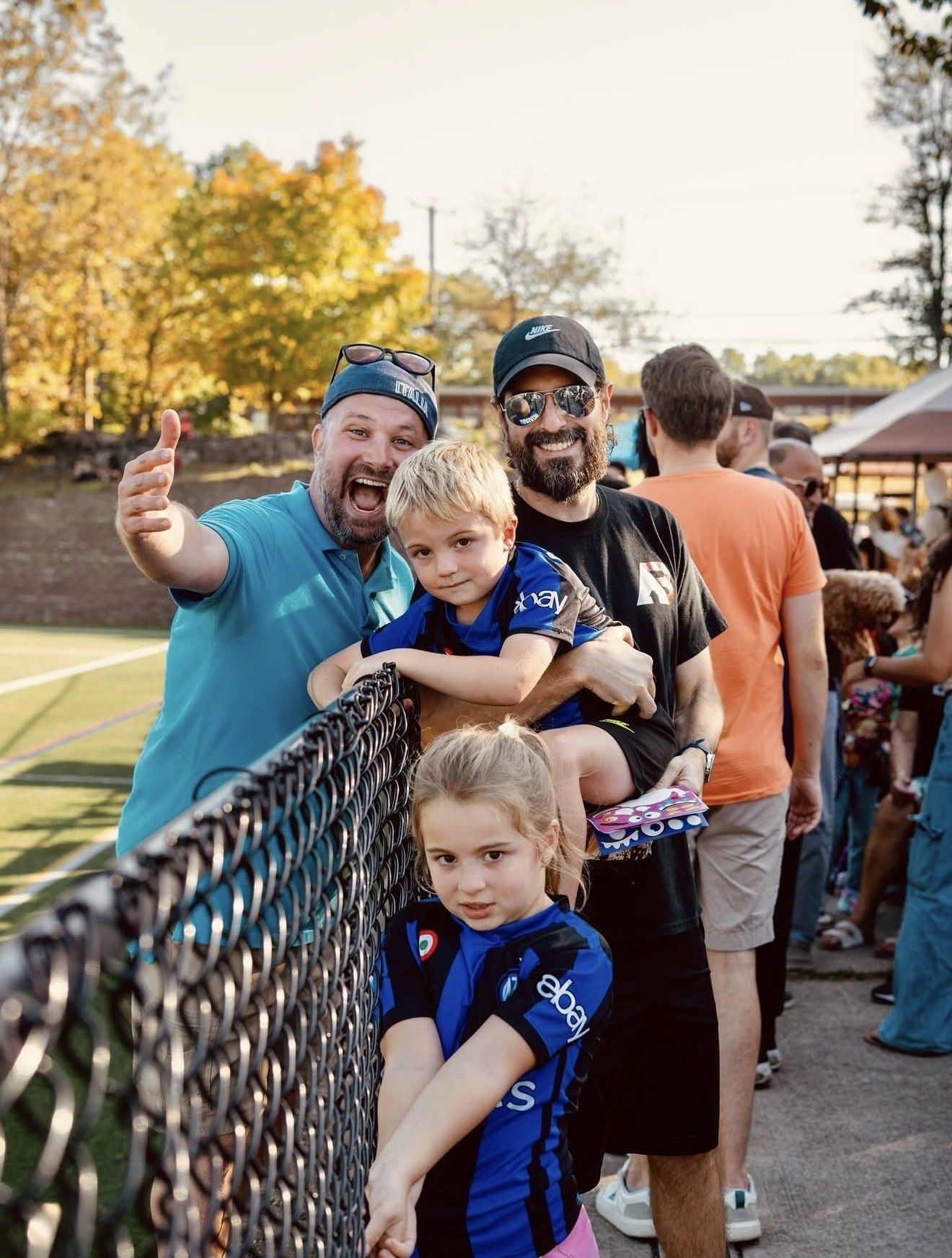 A family seated in the stands at the Stamford Italian Soccer League Finals Celebration