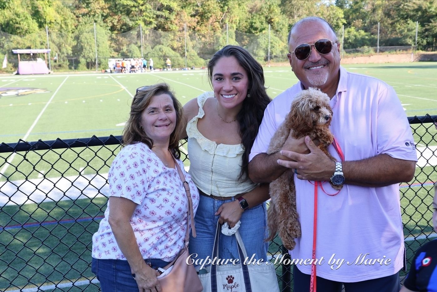 A family and their dog on the sideline at the 2025 Finals Celebration.