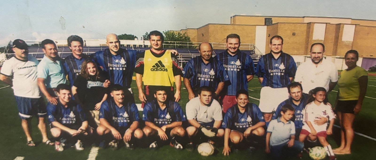 An early Stamford Italian Soccer League team photograph: players in striped Benistar kits with family members, lined up on the field